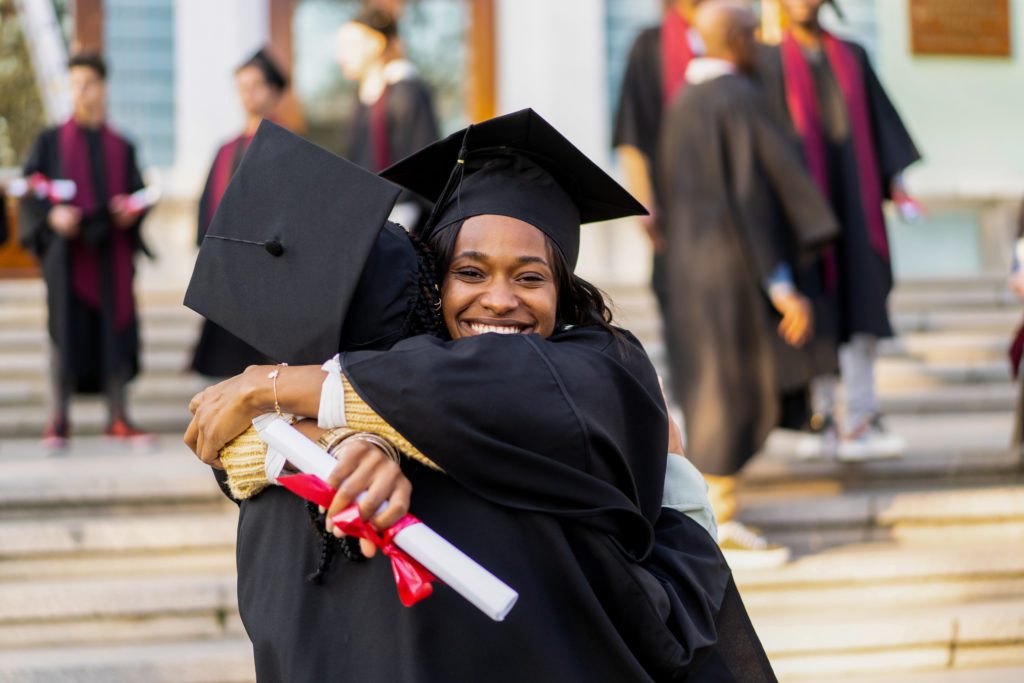 person hugging friend at graduation